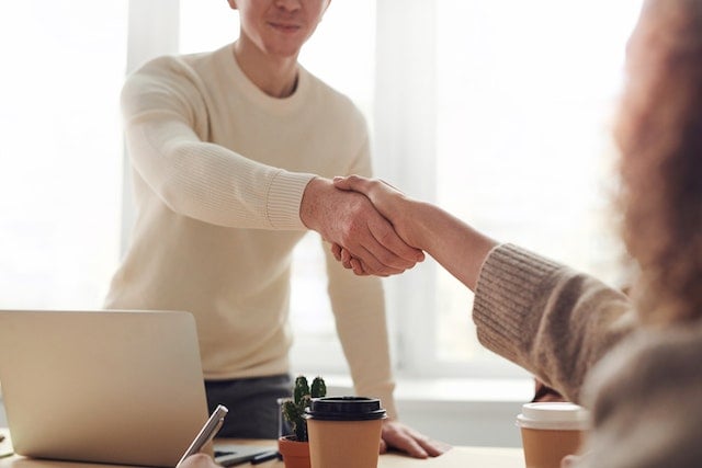 people meeting and shaking hands for tenant screening interview